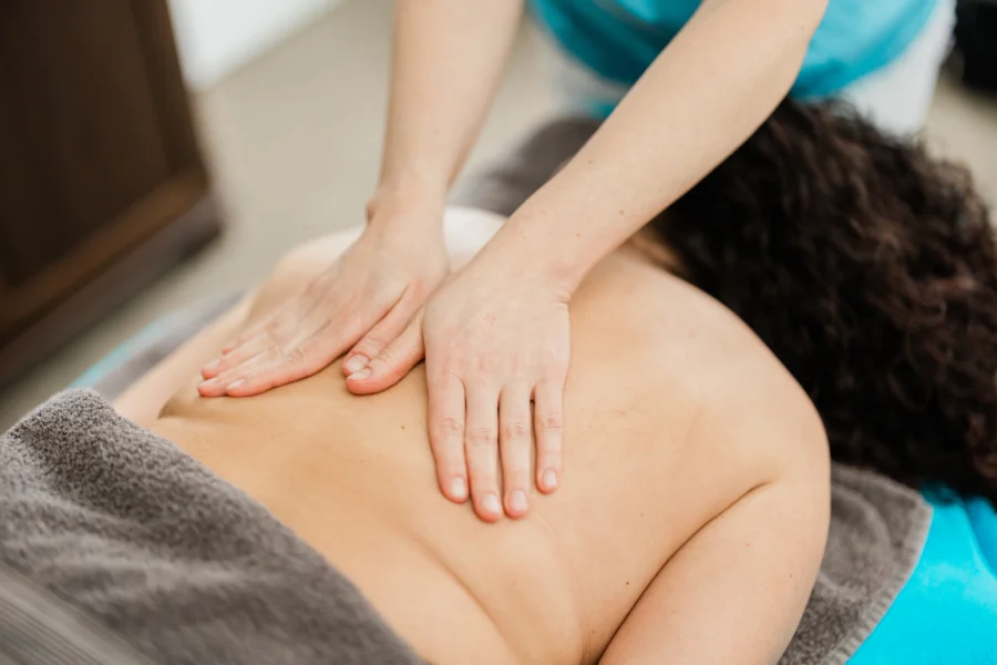 Klassische Massage Anwendung einer gezielten Grifftechnik am Rücken von kranial nach kaudal