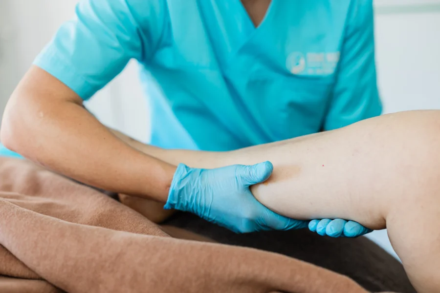 Manuelle Lymphdrainage Wuppertal – Alex führt den Schöpfgriff an der Wade aus, gezielte Grifftechnik zur Aktivierung des Lymphflusses in der Praxis Domo Massage Wuppertal-Ronsdorf