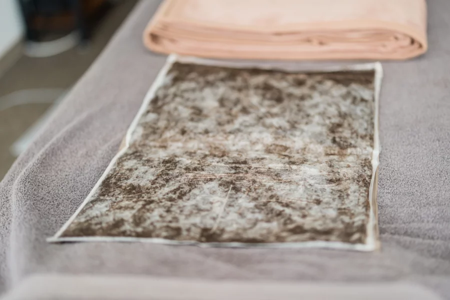 Naturmoor – wohltuende Wärme aus der Natur Naturmoor-Packung auf einem Handtuch vorbereitet für eine Fangoanwendung