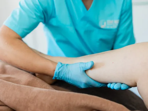 Manuelle Lymphdrainage Wuppertal – Alex führt den Schöpfgriff an der Wade aus, gezielte Grifftechnik zur Aktivierung des Lymphflusses in der Praxis Domo Massage Wuppertal-Ronsdorf